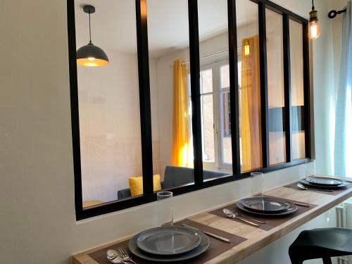 uma mesa com pratos e copos em cima em Appartements Voltaire - Carcassonne Centre em Carcassonne