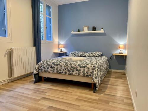 カルカソンヌにあるAppartements Voltaire - Carcassonne Centreのベッドルーム1室(ベッド1台、ランプ2つ、テーブル2台付)