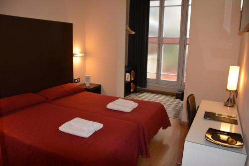 a hotel room with a red bed and a window at Center Gran Via in Barcelona
