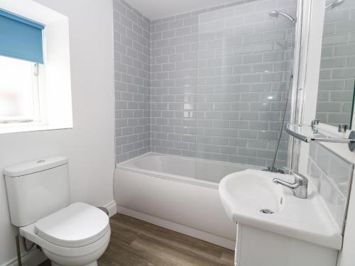 y baño con aseo, bañera y lavamanos. en Waveney View Cottage en Great Yarmouth