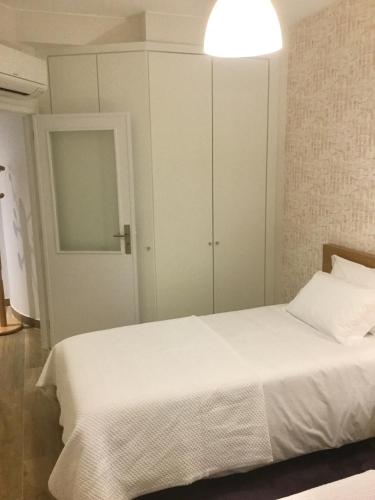 a bedroom with a white bed and a cabinet at Central & Charming Clérigos Appartments in Porto