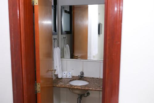 a bathroom with a sink and a mirror at Palace Hotel in Araguari