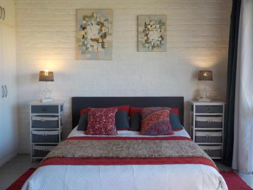 a bedroom with a bed with two dressers and two lamps at Dejeps in Punta Del Diablo