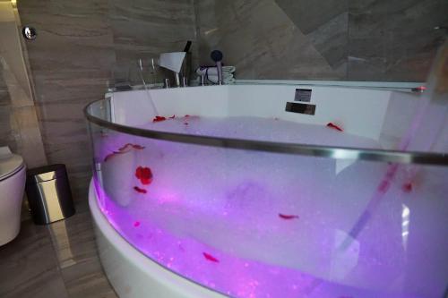 a bathroom with a tub with pink dye in it at Apartment De Luna Belgrade in Belgrade
