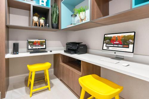 a office with a desk with two monitors and a yellow stool at Holiday Inn Yakima by IHG in Yakima