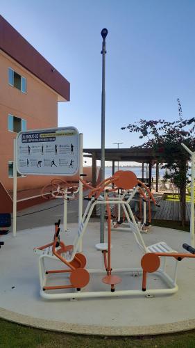 a playground with orange and white equipment in a park at APARTAMENTO EM ARRAIAL DO CABO - RJ in Arraial do Cabo