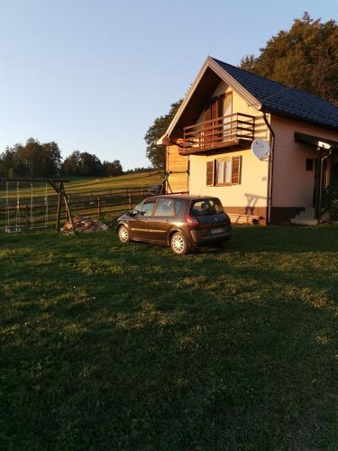 a car parked in a yard in front of a house at Vikendica Sekulić in Bajina Bašta