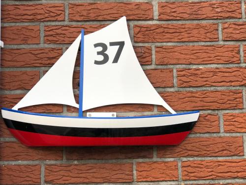 a toy boat hanging on a brick wall at Nordstern in Büdelsdorf