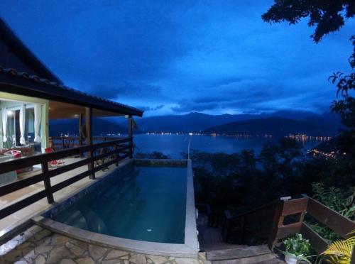 uma villa com piscina à noite em Chalé da Clarissinha em Mangaratiba
