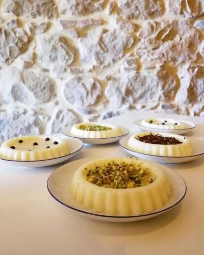 a group of desserts on plates in front of a stone wall at Il Miglio in Più in Castel di Tusa