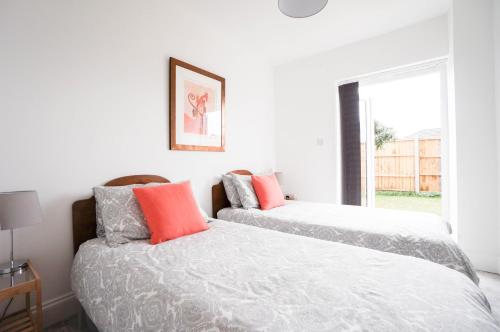 dwa łóżka siedzące obok siebie w sypialni w obiekcie AAA Stay Garden Apartment w mieście Thatcham