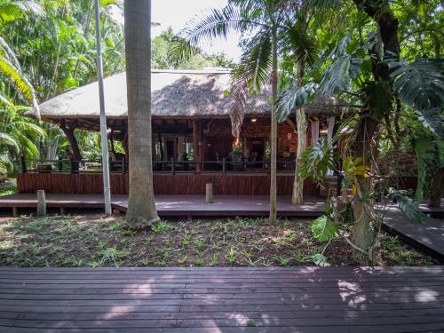 a restaurant in the middle of a forest with palm trees at Kruger Eden Lodge in Marloth Park