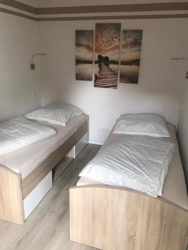 two beds in a room with pictures on the wall at Ferienwohnung Blume in Schwielowsee