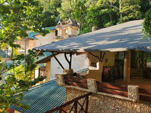 a house with a blue roof and a wooden fence at Altos de Caño Hondo in Los Guineos Perdidos