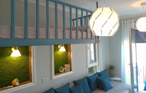 a living room with a blue couch and a staircase at Welcome Beach Apartment in Hamallë