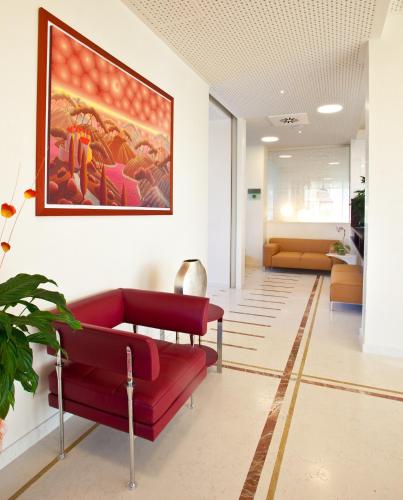 a living room with a red couch and a painting on the wall at Breaking Business Hotel in Mosciano SantʼAngelo