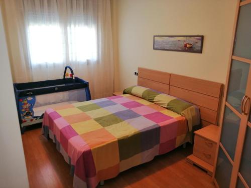 Dormitorio pequeño con cama y cuna en Apartamento playa Cambrils edificio Torresol, en Cambrils