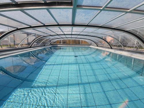 une grande piscine avec un plafond en verre dans l'établissement Krisztián Apartmanház, à Vonyarcvashegy