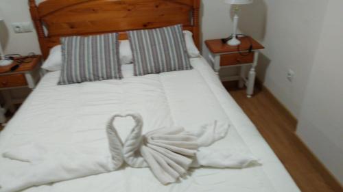 ein weißes Bett mit einem Herz aus Handtüchern in der Unterkunft edificio primavera zona baja in Sierra Nevada