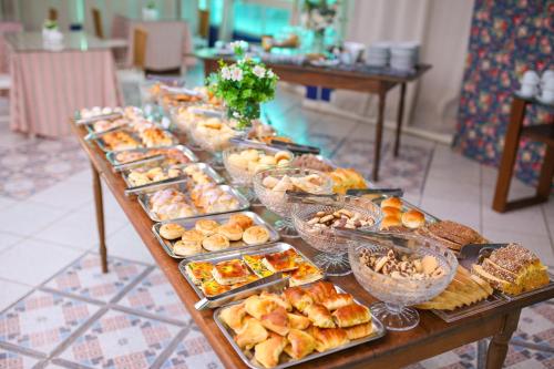 a long table filled with different types of pastries and bread at Palace Hotel in Araguari