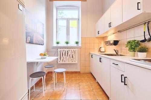 羅茲的住宿－deLux3，厨房配有白色橱柜和2把凳子