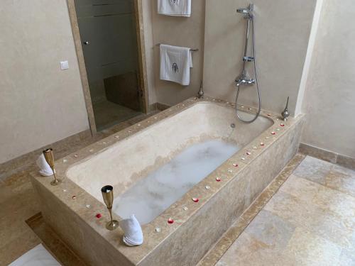 a large bath tub with a shower in a bathroom at LES JARDINS DE MARRAKECH in Marrakech