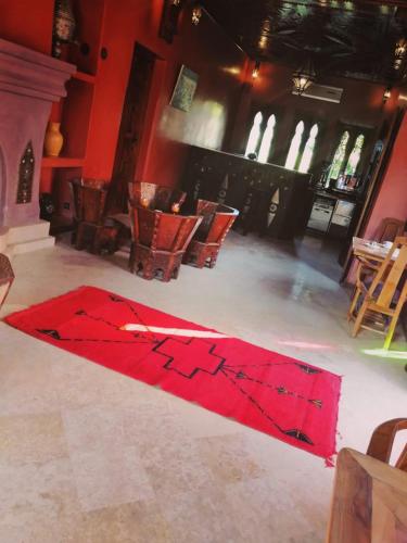 a red rug on the floor in a room with chairs at LES JARDINS DE MARRAKECH in Marrakech