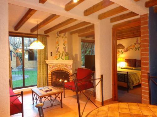 a living room with a fireplace and a bedroom at Hotel Villas Casa Morada in San Cristóbal de Las Casas