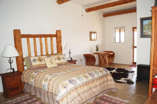 - une chambre avec un lit, une table et des chaises dans l'établissement Rancho Milagro Bed & Breakfast, à Elgin