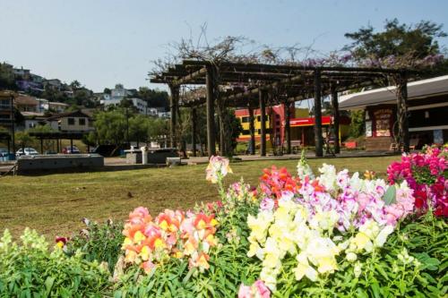 a group of flowers in a park with a pavilion at Verde Vale Hotel in Videira