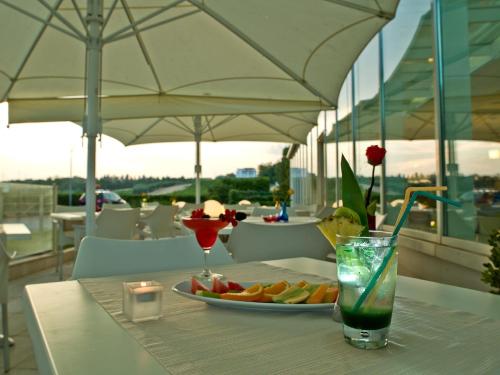 a table with a plate of fruit and a drink at Breaking Business Hotel in Mosciano SantʼAngelo
