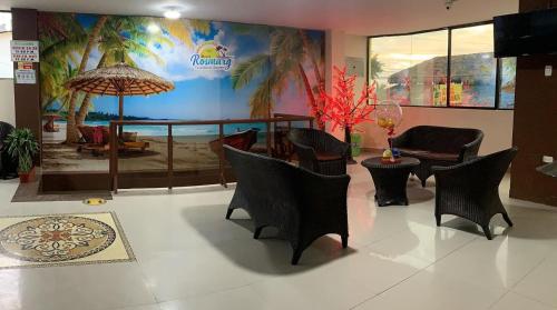 a lobby with chairs and a table and an umbrella at Hotel Rosmarg in Atacames