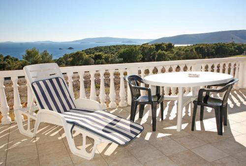 una mesa y sillas en un balcón con vistas al océano en Apartments Barisic Hrvatskih Žrtava 404 Seget Vranjica, en Trogir