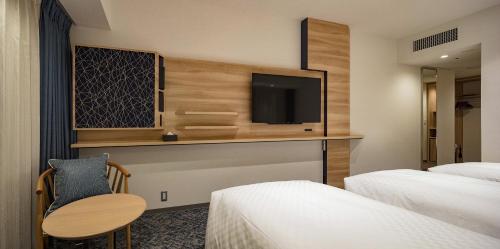 a hotel room with two beds and a tv at Via Inn Prime Nihonbashi Ningyocho in Tokyo