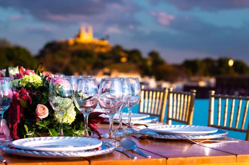 een tafel met wijnglazen en bloemen erop bij Hotel Santa Rosa by Rotamundos in Cholula
