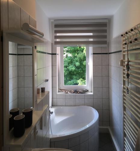 a white tub in a bathroom with a window at FeWo Oberwiesenthal in Kurort Oberwiesenthal