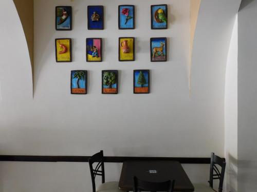 a wall with nine framed pictures on a wall at Hotel Santa Rosa in Cholula