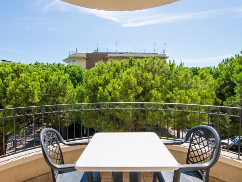 einen weißen Tisch und Stühle auf einem Balkon mit Bäumen in der Unterkunft Engaging Apartment in Riccione with Balcony in Riccione