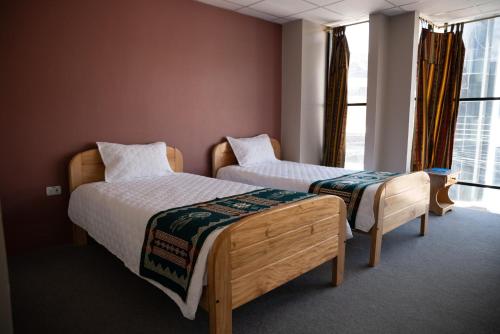 1 dormitorio con 2 camas y ventana en Hotel Chasky, en El Tambo
