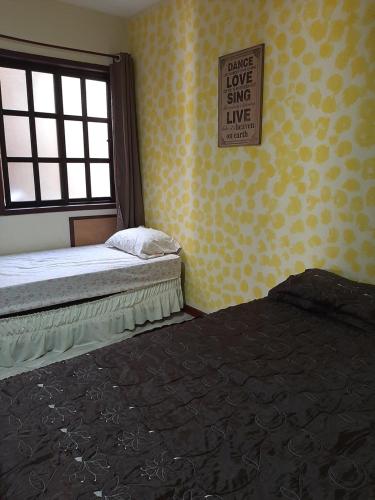 un dormitorio con 2 camas y un cartel que diga "Por favor, amor, canta en vivo" en Praia das Dunas Residence Club, en Cabo Frío