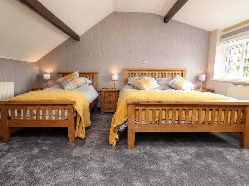 1 Schlafzimmer mit 2 Betten und gelben Decken in der Unterkunft Mayfield Cottage in Blackpool