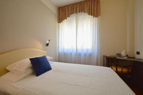 a bedroom with a bed with a blue pillow on it at Best Western Hotel Crimea in Turin