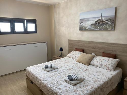a bedroom with a bed with two towels on it at Apartamento Tobias Agaete Parque Playa del Ingles in San Bartolomé de Tirajana