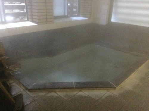 a bath tub in a room with a window at Chitosekan in Nozawa Onsen