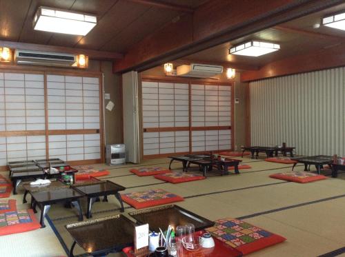 a large room with tables and mats on the floor at Chitosekan in Nozawa Onsen