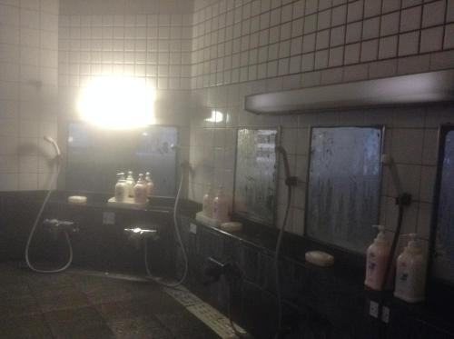 a bathroom with a sink and a light on the wall at Chitosekan in Nozawa Onsen