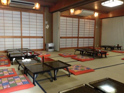 a room with tables and mats on the floor at Chitosekan in Nozawa Onsen