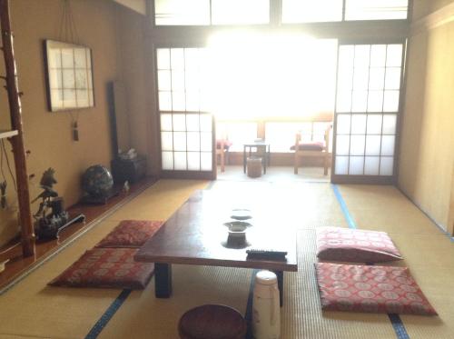 a living room with a table and some rugs at Chitosekan in Nozawa Onsen