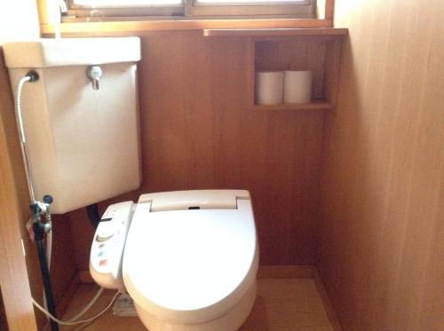 a bathroom with a white toilet and a window at Chitosekan in Nozawa Onsen