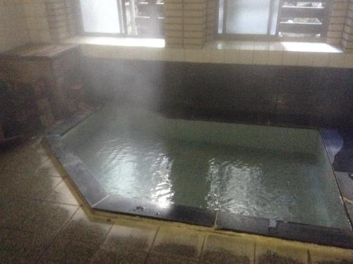 a large pool of water in a room at Chitosekan in Nozawa Onsen